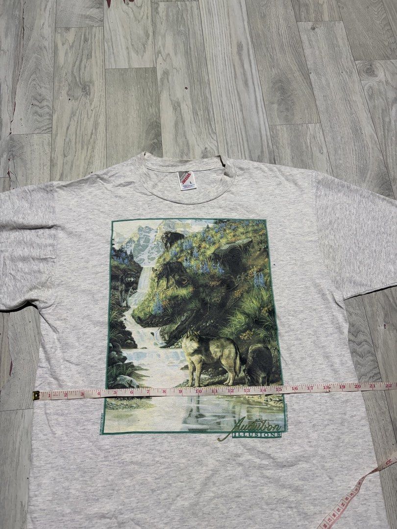 Jerzees Vintage Audubon Illusions 1995 Rusty Rust T-Shirt (Category: Tshirts & Polo Shirts ) located in Guihulngan. Submitted by fbthriftgoodsniace (Listing ID 1454388913, Image 2). Description: - Vintage 1995 Jerzees T-Shirt - Features 'Audubon Illusions' graphic: wolf and waterfall scene - Graphic also includes 'Rusty Rust' and 'Prince Island Apparel' - Approximate Measurements: 20 inches wide x 28 inches long - Excellent vintage condition, a u