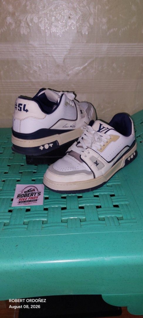 Louis Vuitton LV Trainer "54" Sneakers White Navy (Category: Sneakers) located in Candelaria. Submitted by RHOBZ29 (Listing ID 1454510530, Image 1). Description: - Authentic Louis Vuitton sneakers - Color: White and Navy - Features iconic LV monogram pattern - '54' detail on the heel - 'VUITTON' text on the soles - Ideal for casual and everyday wear - Please check photos for detailed condition.