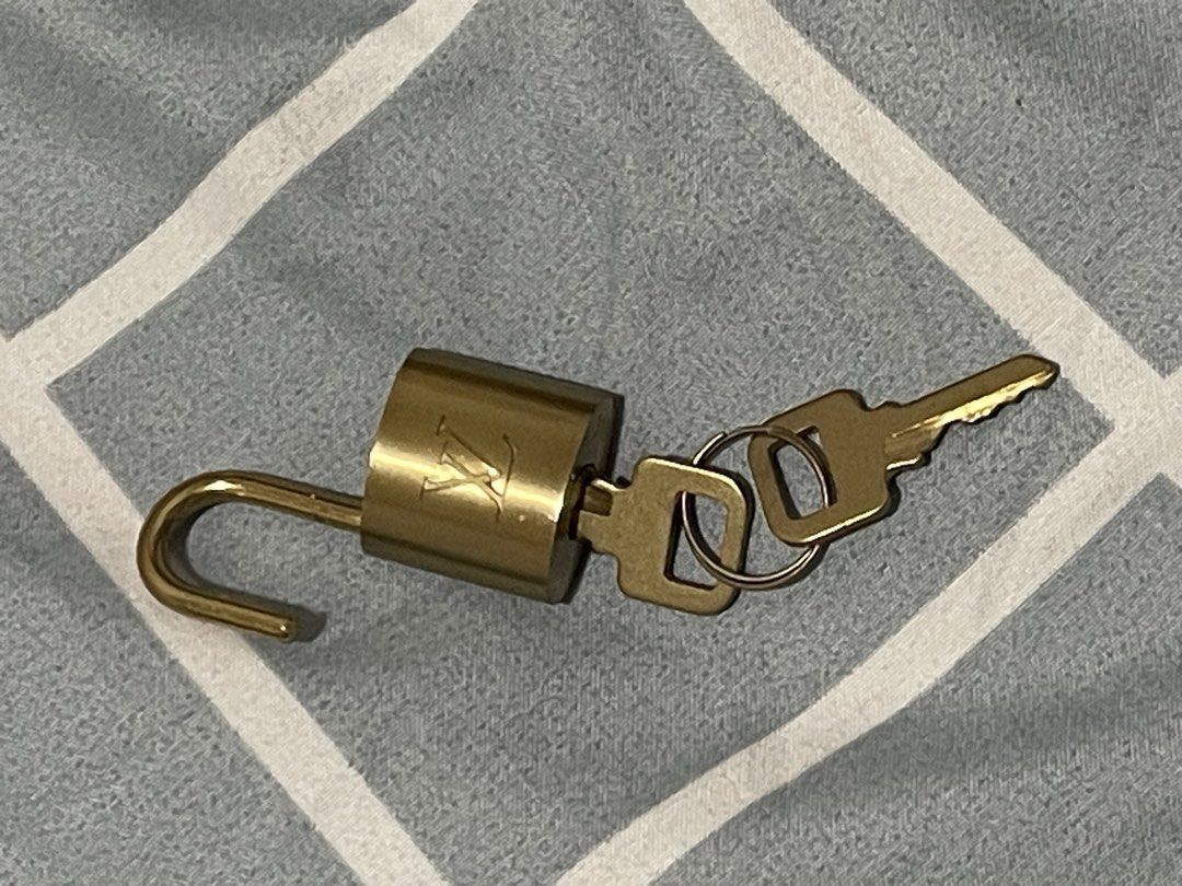 LV Lock Set (Category: Luxury Accessories) located in Las Pinas. Submitted by marqusasasas (Listing ID 1454469479, Image 2). Description: Selling a Louis Vuitton lock set in a classic gold-tone finish. Includes the padlock, matching keys, and attached key ring/chain as shown in the photos. * Brand: Louis Vuitton * Color: Gold tone * Condition: Lightly used * Includes: Lock, keys, and key ring/chain * Gender: Unisex * Great as a replacement lock/a