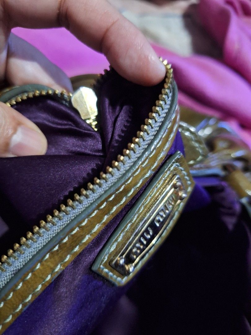 Miu Miu Patent Leather Handbag (Category: Luxury Bags & Wallets) located in Quezon City. Submitted by cloudymay (Listing ID 1450872247, Image 3). Description: - Glossy olive green Miu Miu handbag - Prominent Miu Miu logo - Secure magnetic closure - Unique lock detail with chain - Crinkled patent leather finish - Sturdy handles attached with buckles - Ideal for stylish everyday use * Accesories not included. Its just a suggestion as to how I style
