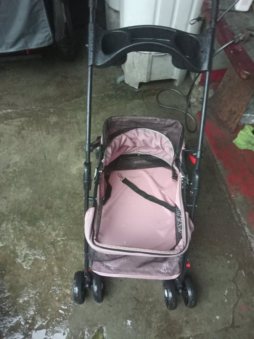 Pink Pet Stroller for Small Dogs or Cats (Category: Homes & Other Pet Accessories) located in Quezon City. Submitted by madelrivera (Listing ID 1454390276, Image 2). Description: - Used pet stroller, perfect for small dogs or cats. - Stylish pink fabric with a sturdy black frame. - Includes an internal safety strap for your pet's security. - Folds easily for convenient storage. - Wheels are fully functional for smooth rides..