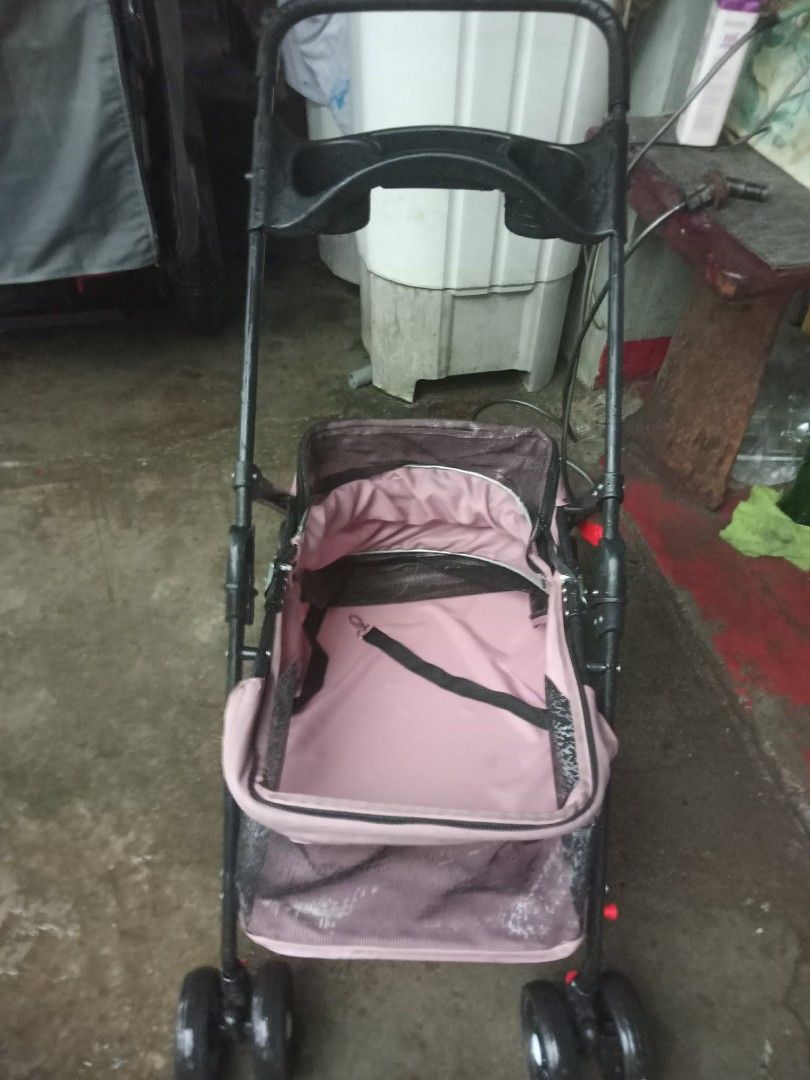 Pink Pet Stroller for Small Dogs or Cats (Category: Homes & Other Pet Accessories) located in Quezon City. Submitted by madelrivera (Listing ID 1454390276, Image 1). Description: - Used pet stroller, perfect for small dogs or cats. - Stylish pink fabric with a sturdy black frame. - Includes an internal safety strap for your pet's security. - Folds easily for convenient storage. - Wheels are fully functional for smooth rides..