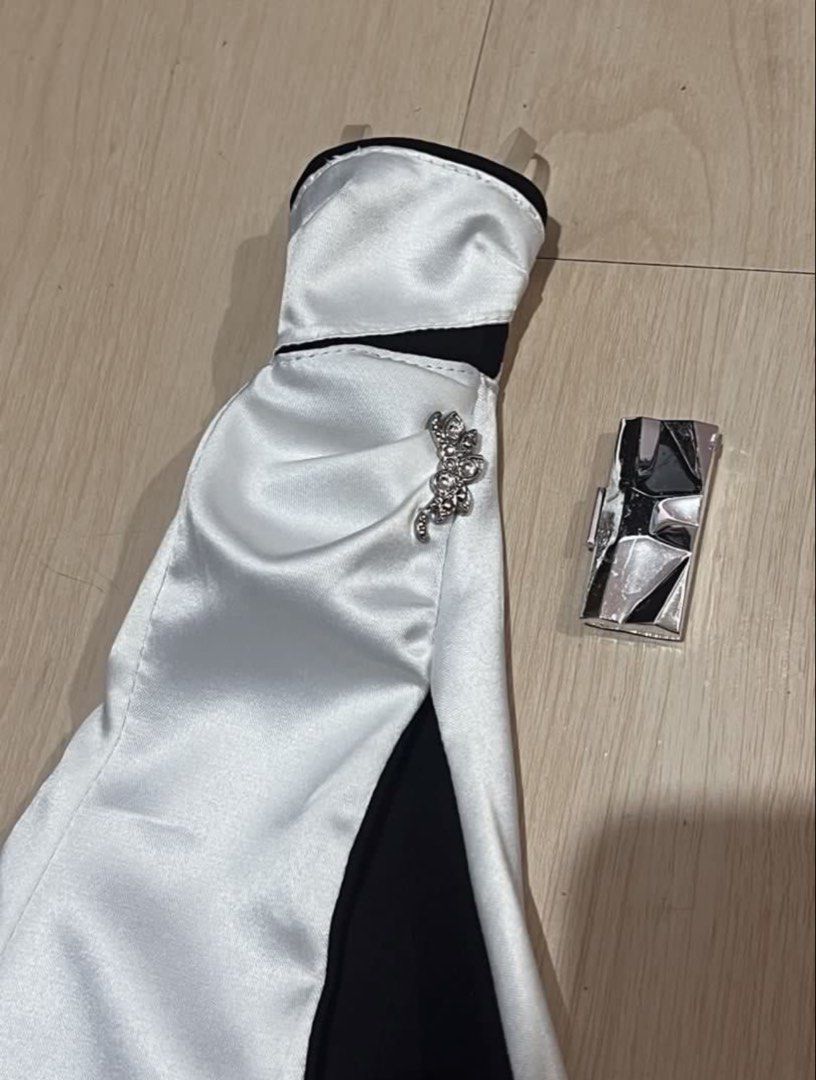 PTMI Barbie gown (Category: Evening dresses & gowns) located in Rizal. Submitted by arryn (Listing ID 1454550645, Image 2). Description: - Elegant black and white strapless evening gown for Barbie dolls. - Features a daring high slit for a glamorous look. - Adorned with a beautiful jeweled accent on the side. - Includes a stylish small silver clutch purse. - Ideal for Barbie collectors and imaginative play scenarios. Pm for details.