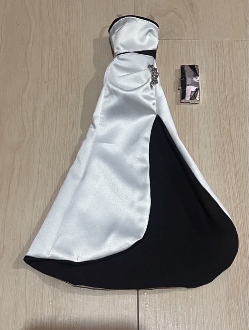 PTMI Barbie gown (Category: Evening dresses & gowns) located in Rizal. Submitted by arryn (Listing ID 1454550645, Image 1). Description: - Elegant black and white strapless evening gown for Barbie dolls. - Features a daring high slit for a glamorous look. - Adorned with a beautiful jeweled accent on the side. - Includes a stylish small silver clutch purse. - Ideal for Barbie collectors and imaginative play scenarios. Pm for details.