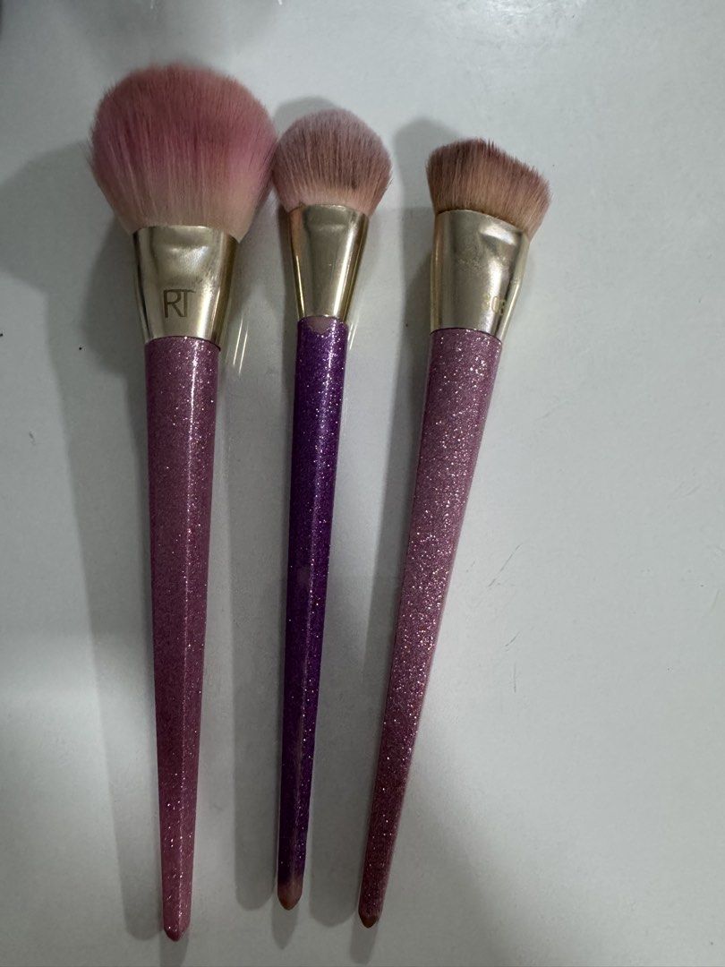 Real Techniques Glitter Makeup Brush Set (Category: Makeup) located in Manila. Submitted by decluterthings888 (Listing ID 1454474408, Image 1). Description: - Set includes Real Techniques 300 Powder brush. - Two additional brushes with eye-catching glitter handles (purple and pink). - Brush heads are in pink and brown shades. - Adds a touch of sparkle and functionality to your makeup collection..