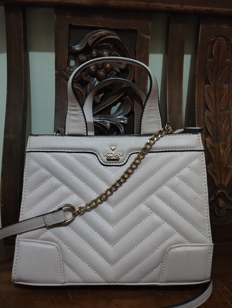 Secosana Quilted Handbag with Chain Strap (Category: Shoulder Bags) located in Manila. Submitted by ljaneee (Listing ID 1454438245, Image 2). Description: - Secosana handbag in light pink/beige - Elegant quilted chevron pattern on the front - Comfortable top handles - Includes a detachable chain strap for versatile wear - Stylish gold hardware details - Subtle Secosana logo on the front - Ideal for everyday use or evening events.