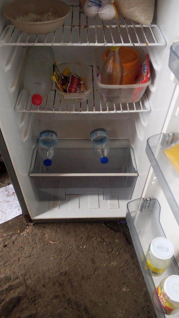 Sharp Refrigerator (Category: Refrigerators and Freezers) located in Manila. Submitted by utopia_67676c (Listing ID 1454408022, Image 2). Description: - Sharp refrigerator - Top freezer, bottom fridge configuration - Silver exterior finish - Visible interior shelves - Minor cosmetic scuffs on exterior - Fully functional and works well.