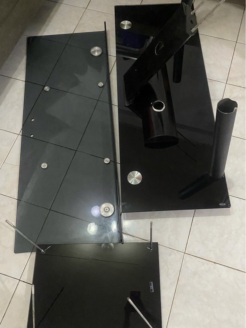 Tempered Glass TV Table/ Console (Category: TV Consoles) located in Quezon City. Submitted by faeriii.lunar (Listing ID 1454396341, Image 1). Description: Tempered Glass TV/Entertainment Table – Needs Assembly ✔️ Complete parts included ✔️ Tempered black glass shelves ✔️ Sturdy metal frame ✔️ Disassembled for easier transport ✔️ Ready to assemble Condition: Used, in good condition. Glass panels are intact, and all parts are included. Still negoti