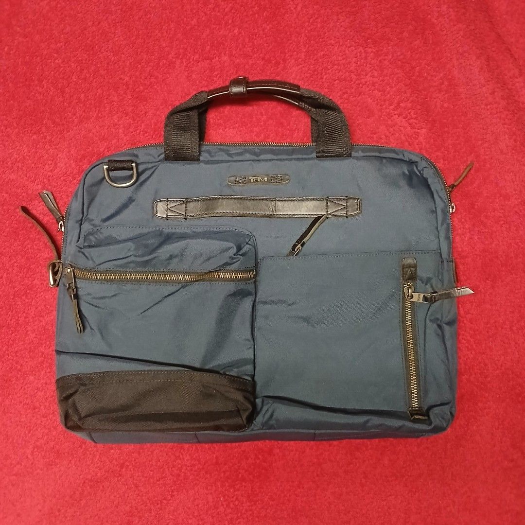 Tumi Navy Blue Ballistic Nylon Briefcase / Laptop Bag (Category: Briefcases) located in Cagayan de Oro. Submitted by susanthrifts (Listing ID 1454506263, Image 1). Description: ​Brand: Tumi ​Model / Style Ref: 61011INDOP ​Type: Briefcase / Laptop Attache / Work Bag ​Color: Navy Blue with Black Leather Trim & Dark Grey Interior ​Material: Ballistic Nylon Exterior, Nylon Lining, Genuine Leather Accents ​Features: ​Multi-compartment main interior wi