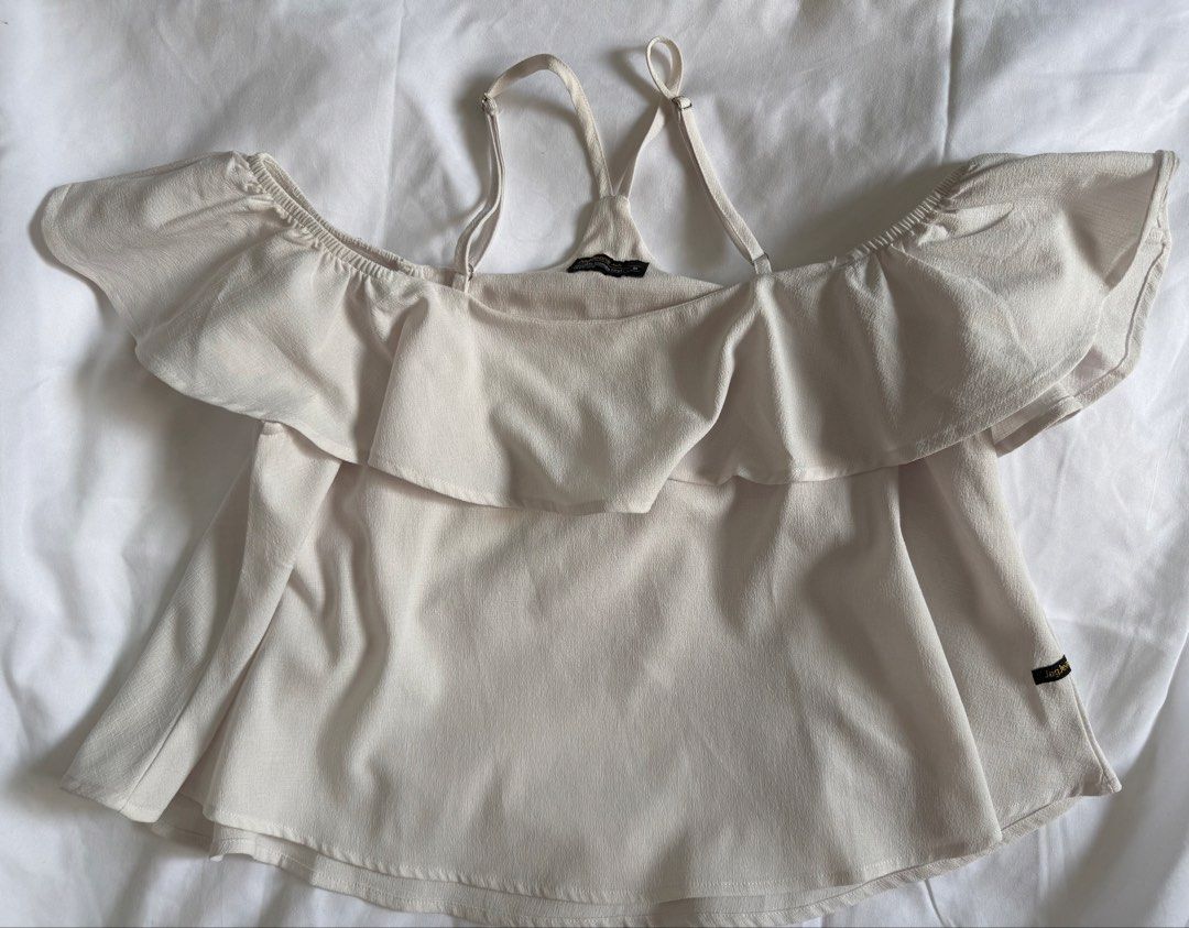 White off-shoulder ruffled top with adjustable straps (Category: Blouses) located in Antipolo. Submitted by errrilemon (Listing ID 1454512627, Image 3). Description: - Cute white off-shoulder top with strap - Ruffled detail across the chest - Flutter sleeves - Adjustable straps for a perfect fit - Layered design at the bottom - Versatile: pairs well with jeans or shorts - Ideal for casual outings.