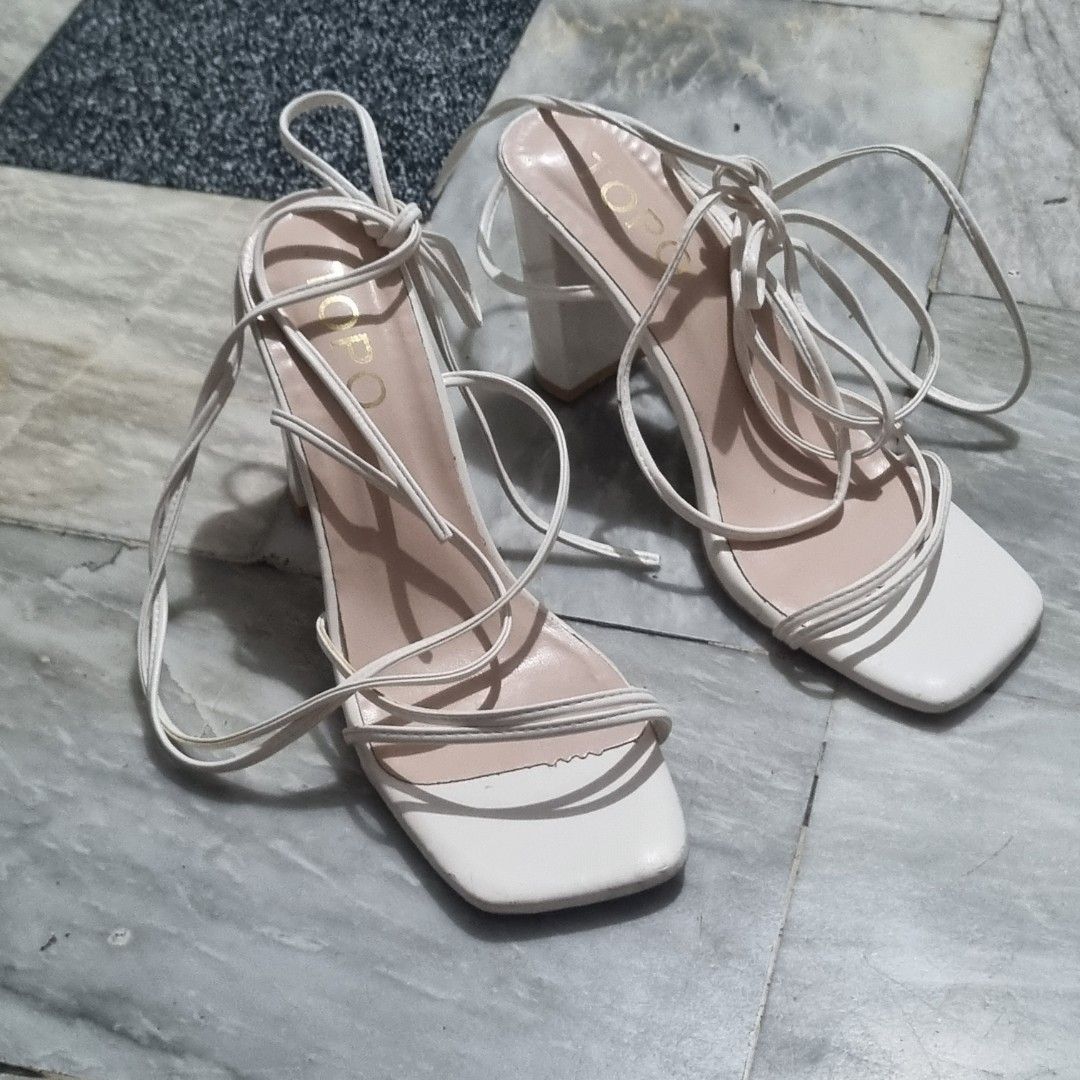 White Strappy Lace-Up Block Heels (Category: Sandals) located in Las Pinas. Submitted by cozychic19 (Listing ID 1454445340, Image 1). Description: Featuring an open square toe and delicate wrap-around ankle ties RFS: Wrong Size With box Minor scuffing, peeling, marks on the heel edge.