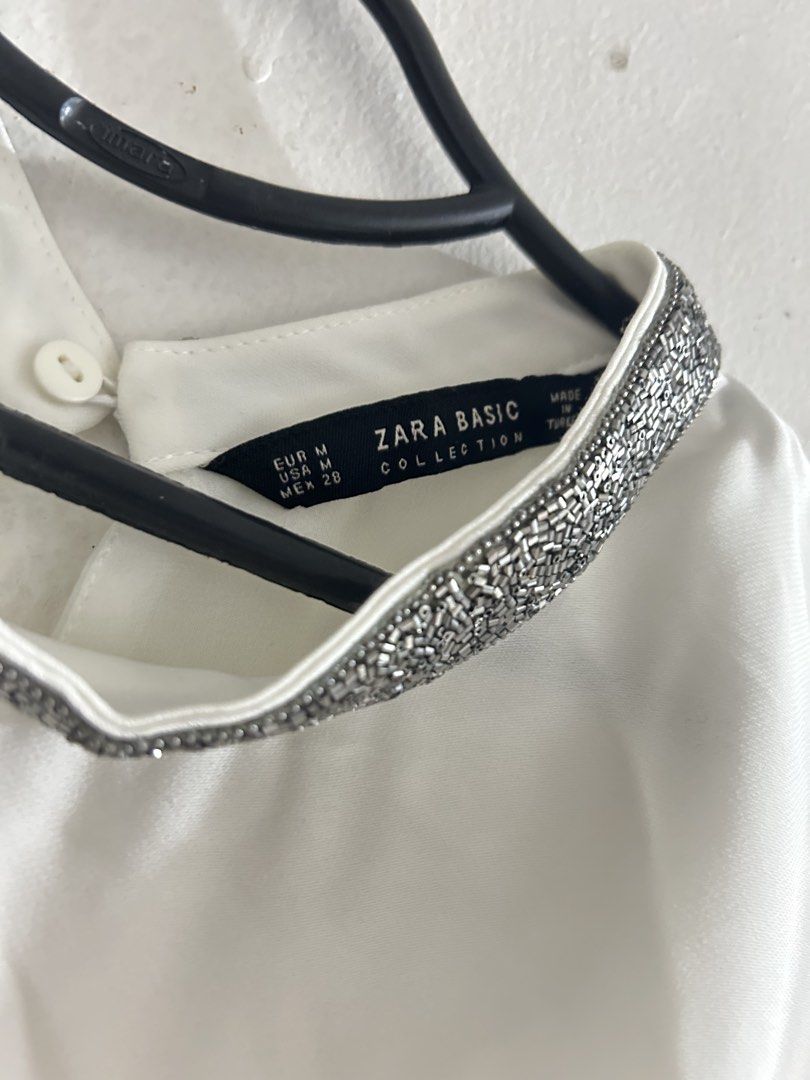 Zara Basic Collection White Sleeveless Top with Embellished Collar (Category: Sleeveless) located in Sorsogon. Submitted by jonacel (Listing ID 1454467610, Image 2). Description: - White sleeveless top from Zara Basic Collection - Size M - Layered hem detail - Beautiful embellished collar with silver beads - Perfect for dressing up or down - Pairs well with skirts or trousers.
