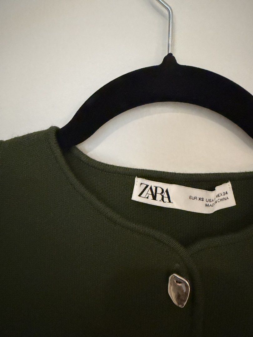 Zara Green Button Up Knit Cropped Top (Category: Coats, Jackets and Outerwear) located in Taguig. Submitted by hertrinkets (Listing ID 1454414902, Image 2). Description: - Zara olive green knit cropped cardigan - Sleeveless design - Silver button details down the front - Perfect for layering or wearing solo - Highly versatile piece.