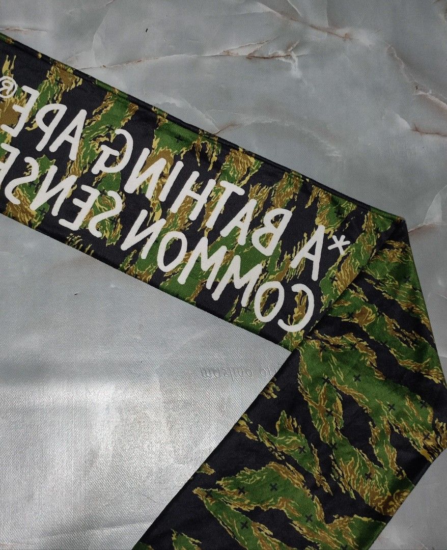 A BATHING APE x COMMON SENSE Tiger Camo Scarf (Category: Luxury Accessories) located in Taguig. Submitted by inzanne.vesture (Listing ID 1454722459, Image 2). Description: - Authentic A BATHING APE® x COMMON SENSE collaboration scarf. - Features iconic tiger camouflage print. - Bold white text branding across the center. - Perfect accessory to elevate your style. - Approximate length: 140cm..