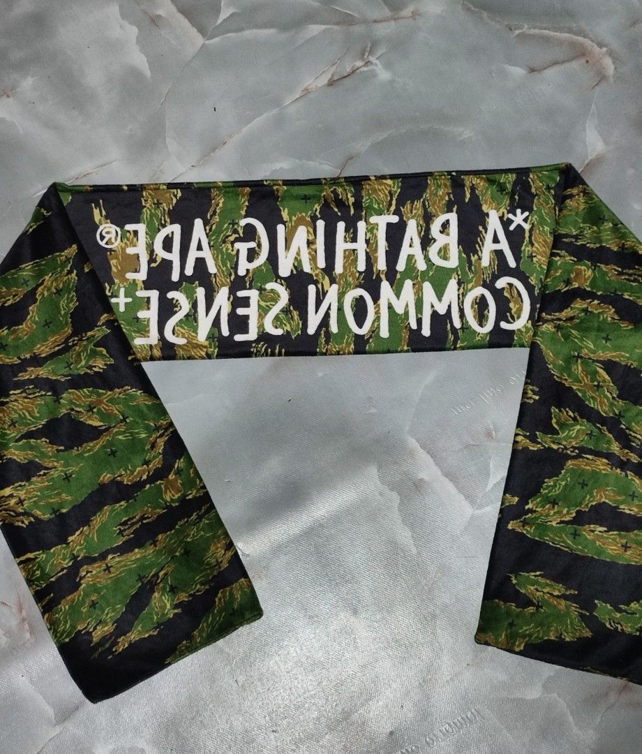 A BATHING APE x COMMON SENSE Tiger Camo Scarf (Category: Luxury Accessories) located in Taguig. Submitted by inzanne.vesture (Listing ID 1454722459, Image 1). Description: - Authentic A BATHING APE® x COMMON SENSE collaboration scarf. - Features iconic tiger camouflage print. - Bold white text branding across the center. - Perfect accessory to elevate your style. - Approximate length: 140cm..