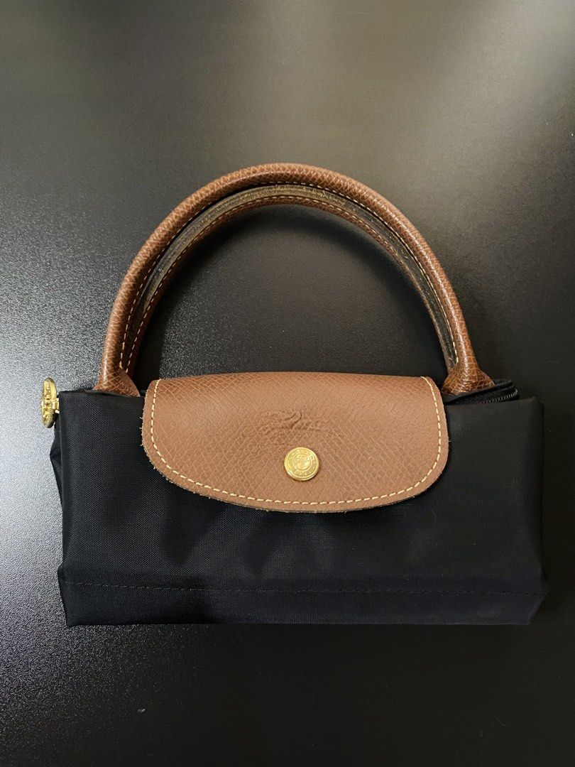 Authentic Longchamp Le Pliage Small Short Handle (Category: Luxury Bags & Wallets) located in Manila. Submitted by glen_n (Listing ID 1454633927, Image 3). Description: Authentic Longchamp Le Pliage Small Short Handle Selling this 100% Authentic Longchamp Le Pliage Small (Short Handle) in classic Black! Purchased in the UK. 🇬🇧 Condition: Good used condition. Shows normal signs of wear, including minor fading on the zipper pull hardware, consist