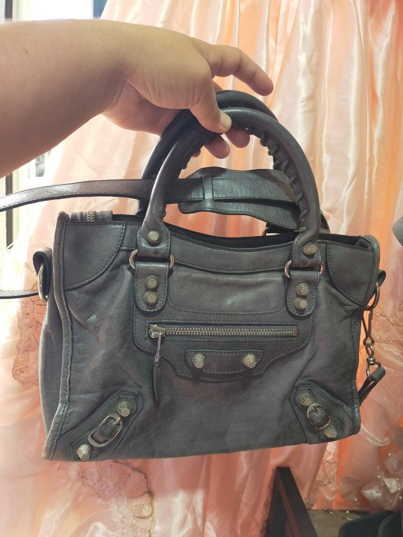 Balenciaga (Category: Luxury Bags & Wallets) located in Manila. Submitted by buynow328 (Listing ID 1454588599, Image 1). Description: - Authentic Grey Leather Balenciaga City Bag - Signature Balenciaga studs and hardware - Top handles and detachable shoulder strap - Front zip pocket - Signs of wear on leather and hardware consistent with use - Overall still a great and stylish bag.