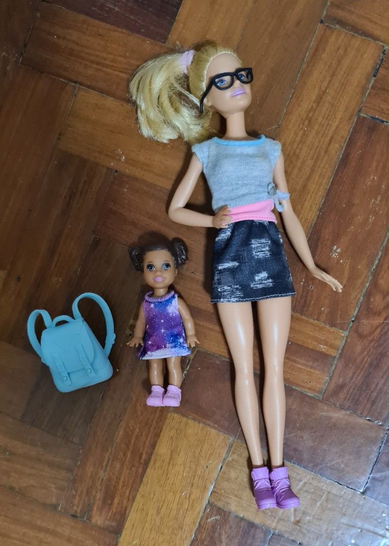 Barbie Dolls with Bunk Bed and Accessories (Category: Kids Toys) located in Manila. Submitted by lc_declut (Listing ID 1454667486, Image 1). Description: - Barbie doll with blonde ponytail, glasses, grey top, and denim skirt. - Smaller doll with dark curly hair wearing a galaxy-print dress. - Pink Barbie bunk bed with a ladder and white accents. - Light blue backpack included. - Encourages imaginative play..