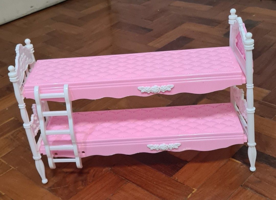 Barbie Dolls with Bunk Bed and Accessories (Category: Kids Toys) located in Manila. Submitted by lc_declut (Listing ID 1454667486, Image 2). Description: - Barbie doll with blonde ponytail, glasses, grey top, and denim skirt. - Smaller doll with dark curly hair wearing a galaxy-print dress. - Pink Barbie bunk bed with a ladder and white accents. - Light blue backpack included. - Encourages imaginative play..