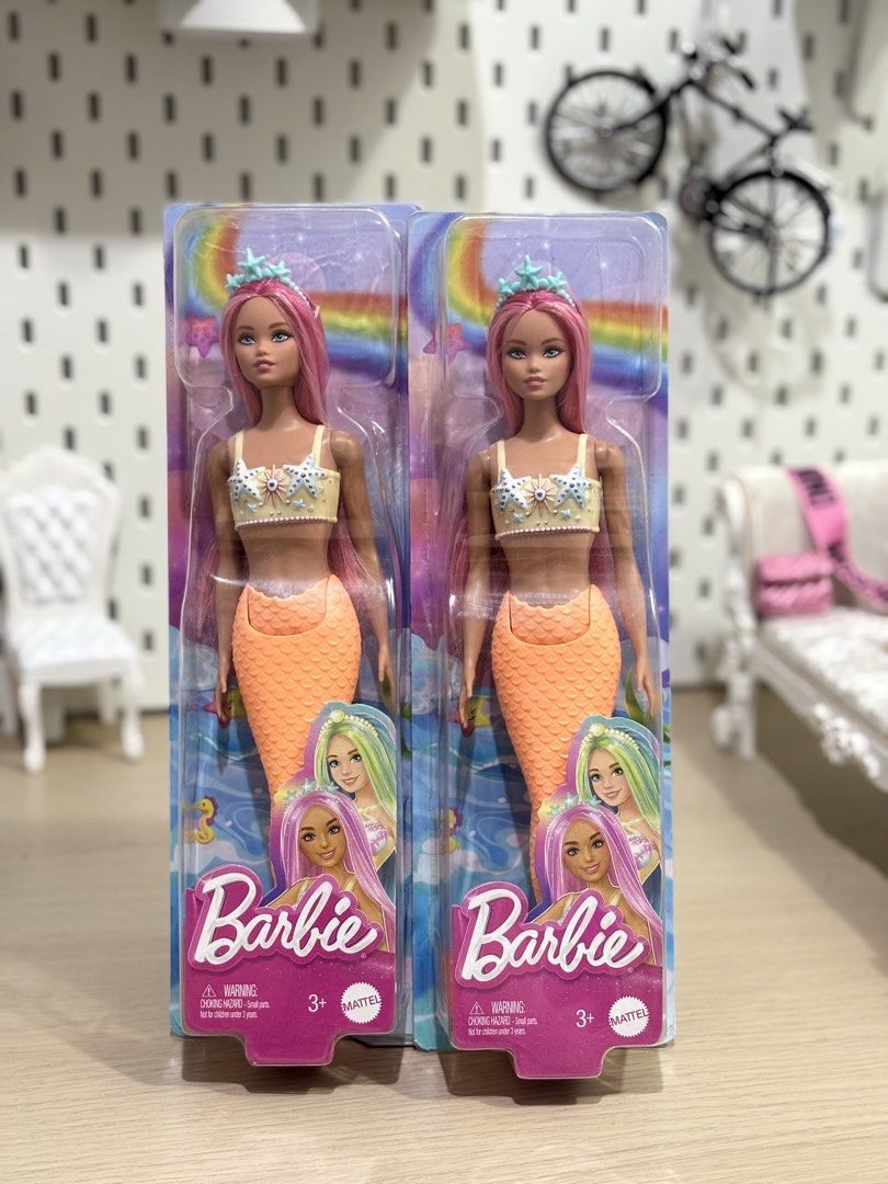 Barbie Mermaid Doll (2 pcs) (Category: Kids Toys) located in Rodriguez. Submitted by michaelstyles (Listing ID 1454748331, Image 1). Description: For only 800php each! 😍 - Set of 2 Barbie mermaid dolls - Features vibrant pink hair - Adorable orange mermaid tails - Each doll wears a seashell bikini top - Topped with a sparkling starfish crown - Packaging boasts a fun rainbow and ocean theme - Ideal for Barbie collectors and imaginative playtime.
