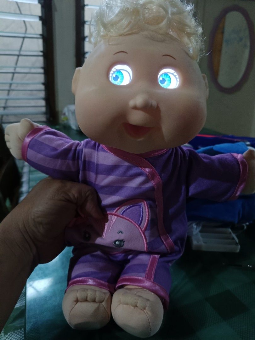 Cabbage Patch Kid Doll Purple Cat Pajamas Light Up Eyes (Category: Babies & Kids Fashion) located in Angeles City. Submitted by mysticdeer-32c4 (Listing ID 1454635280, Image 2). Description: - Adorable Cabbage Patch Kid doll - Features cute purple striped pajamas with a cat design - Eyes light up a cool blue (batteries required) - Approximately 12 inches tall - Perfect fun toy for children.