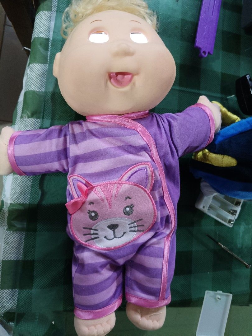 Cabbage Patch Kid Doll Purple Cat Pajamas Light Up Eyes (Category: Babies & Kids Fashion) located in Angeles City. Submitted by mysticdeer-32c4 (Listing ID 1454635280, Image 3). Description: - Adorable Cabbage Patch Kid doll - Features cute purple striped pajamas with a cat design - Eyes light up a cool blue (batteries required) - Approximately 12 inches tall - Perfect fun toy for children.
