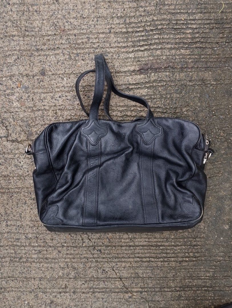 Chrome Hearts Pebbled Leather Bag / Duffel (Category: Luxury Bags & Wallets) located in Baliuag. Submitted by retrovault83 (Listing ID 1454635411, Image 2). Description: Chrome Hearts Pebbled Leather Bag / Duffel ( OFF ONLY ) Front Overlay: Stitched Leather Cemetery Cross patch accented with 3 Silver CH Cross Rivets. Zipper Pulls: Dagger Zip Pulls across compartments (Note: 1 zipper is missing its dagger pull). Exterior Side Studs: Silver Plus/Cr