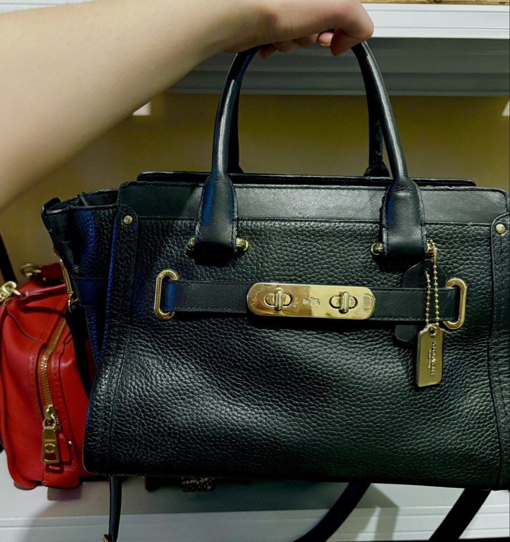 Coach Black Leather Swagger Carryall 27 (Category: Luxury Bags & Wallets) located in Manila. Submitted by katrinaalv30472 (Listing ID 1454560987, Image 1). Description: Classic Coach black leather handbag. Features the signature turn-lock closure. Gold hardware details. Top handles and a detachable shoulder strap. Plenty of space inside for your essentials. A versatile bag for work or weekend..