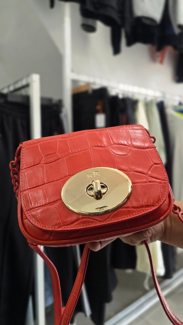 Coach Red Croc Embossed Leather Crossbody Bag (Category: Cross-body Bags) located in Manila. Submitted by nnthrift_ (Listing ID 1454680972, Image 1). Description: - Authentic Orange Coach bag - Luxurious croc embossed leather - Elegant gold hardware - Stylish tassel detail - Convenient chain strap - Interior Coach New York tag - Versatile for nights out or everyday wear.