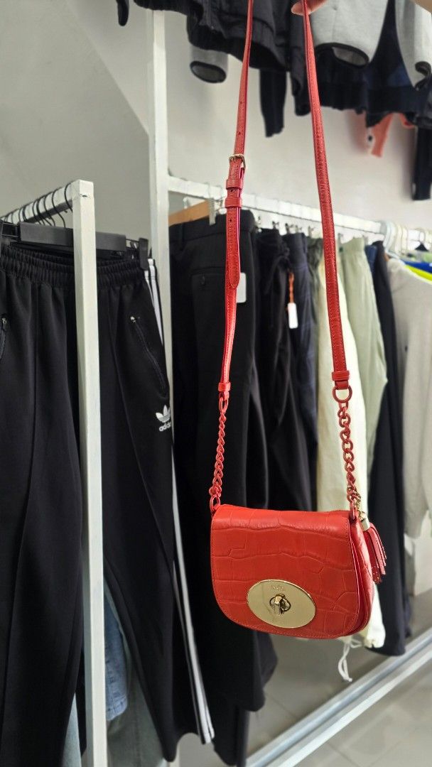 Coach Red Croc Embossed Leather Crossbody Bag (Category: Cross-body Bags) located in Manila. Submitted by nnthrift_ (Listing ID 1454680972, Image 2). Description: - Authentic Orange Coach bag - Luxurious croc embossed leather - Elegant gold hardware - Stylish tassel detail - Convenient chain strap - Interior Coach New York tag - Versatile for nights out or everyday wear.