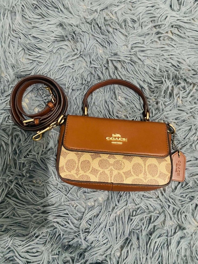 Coach Sling Top Handle Bag (Category: Luxury Bags & Wallets) located in Manila. Submitted by keendog_d33509 (Listing ID 1454683421, Image 1). Description: - Coach sling bag - Signature C print with leather trim and handles - Detachable crossbody strap included - Interior features multiple card slots and a zip pocket - with stain inside the bag -with tag but authenticity not guarantee *You can check all details before you confirm. *NO RETURN, NO R