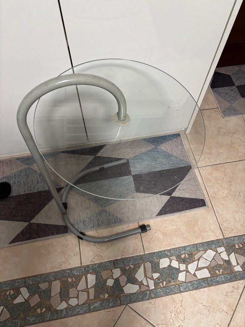Coffee table (Category: Coffee & Tea Tableware) located in Singapore. Submitted by theworldisbig (Listing ID 1454716356, Image 2). Description: - Modern coffee table - Features a unique curved metal frame - Topped with a clear glass surface - Minimalist and stylish design - Suitable for living rooms or bedside.