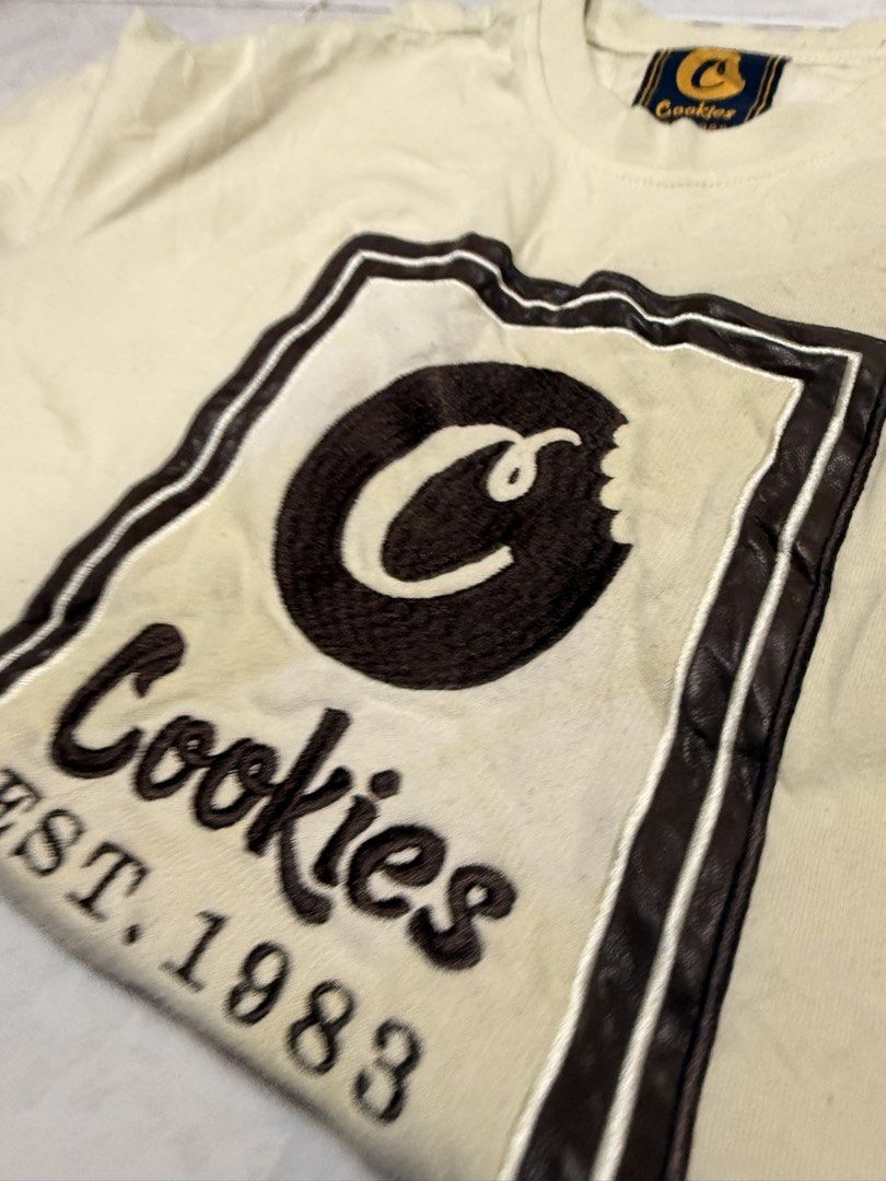 Cookies T-Shirt (Category: Tshirts & Polo Shirts ) located in Manila. Submitted by lostnfound_ph (Listing ID 1454572269, Image 2). Description: - Cream colored Cookies t-shirt - Features iconic Cookies logo with 'Est. 1983' printed below - Tagged size M - Made in China - Great for casual wear.