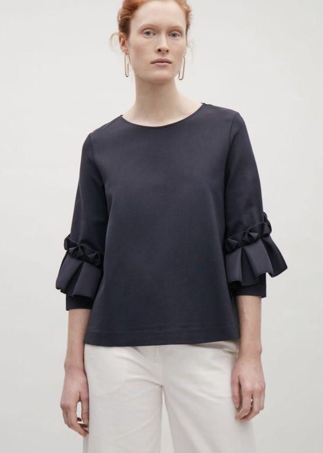 COS Navy Blue Ruffle Sleeve Top Size M (Category: Blouses) located in Mandaluyong City. Submitted by beangoose (Listing ID 1454584253, Image 1). Description: - Navy blue top from COS - Unique ruffle details on sleeves - Three-quarter length sleeves - Crew neck - Size Medium - Perfect with white trousers or jeans.