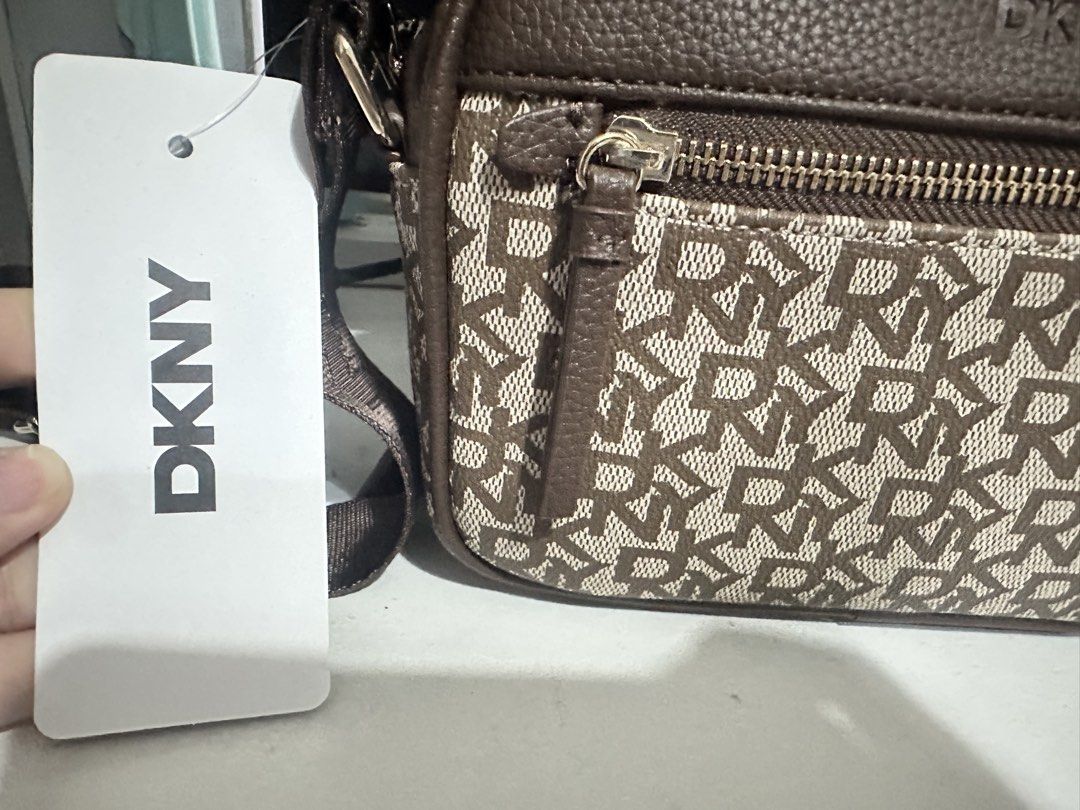 DKNY Chocolate Monogram Crossbody Bag (Category: Cross-body Bags) located in San Fernando. Submitted by nyl001 (Listing ID 1454722549, Image 2). Description: - Original brown DKNY crossbody bag - Features all-over DKNY monogram pattern - Main zippered compartment - Front zippered pocket - Adjustable strap for comfortable wear - Comes with original tag.