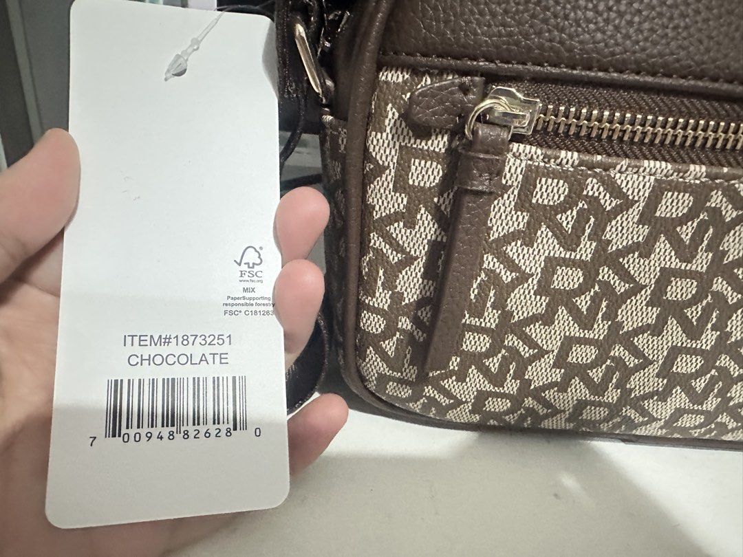 DKNY Chocolate Monogram Crossbody Bag (Category: Cross-body Bags) located in San Fernando. Submitted by nyl001 (Listing ID 1454722549, Image 3). Description: - Original brown DKNY crossbody bag - Features all-over DKNY monogram pattern - Main zippered compartment - Front zippered pocket - Adjustable strap for comfortable wear - Comes with original tag.