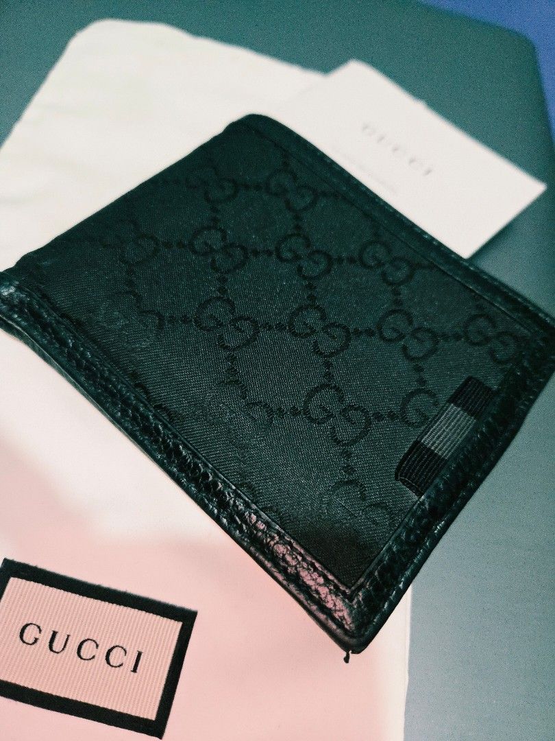 Gucci GG Monogram Canvas Bi-fold Wallet (Category: Luxury Bags & Wallets) located in Cavite. Submitted by elitestuff.carousel (Listing ID 1454745093, Image 1). Description: - Authentic Gucci bi-fold wallet - Classic black GG monogram canvas with leather trim - Multiple card slots inside - Comes with original box and dust bag negotiable at reasonable price.