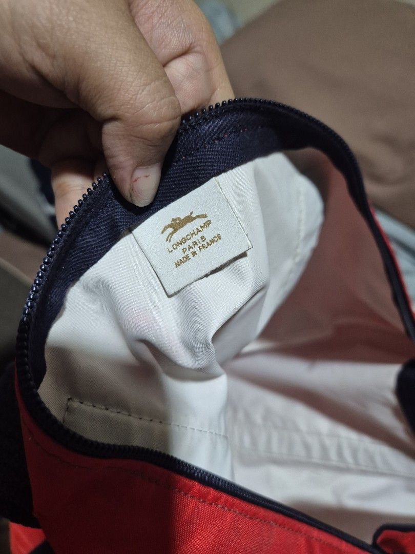 Longchamp Red Nylon Tote Bag (Category: Luxury Bags & Wallets) located in Manila. Submitted by rpaul88 (Listing ID 1454746955, Image 2). Description: - Brand: Longchamp - Material: Nylon - Color: Red - Origin: Made in France - Features: Black straps, black and white logo patch, zipper closure - Ideal for: Everyday use, travel - Interior: Spacious.