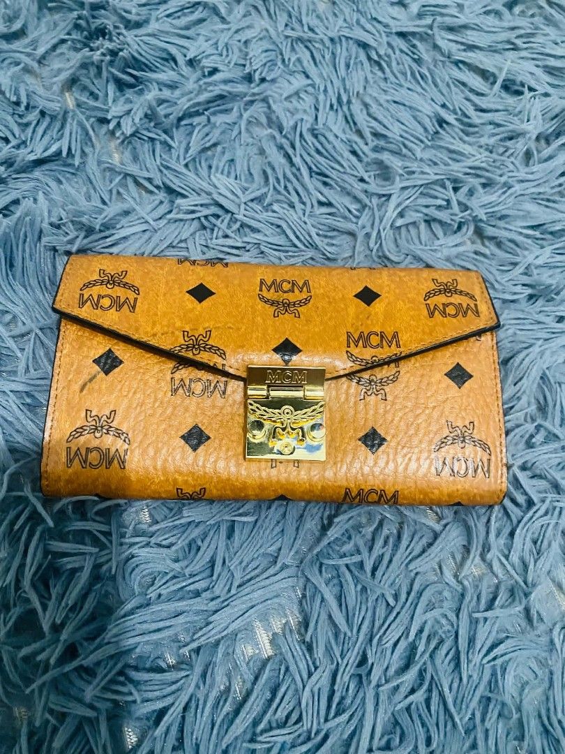 MCM Wallet on chain (Category: Luxury Bags & Wallets) located in Manila. Submitted by keendog_d33509 (Listing ID 1454681745, Image 1). Description: - Classic MCM wallet on chain - Signature Visetos print in warm cognac color - Multiple card slots for organization - Zippered coin pocket - Secure gold hardware closure on the front - Shows some signs of wear. *You can check all details before you confirm. *NO RETURN, NO REFUND ONCE TRANSACTION IS CO