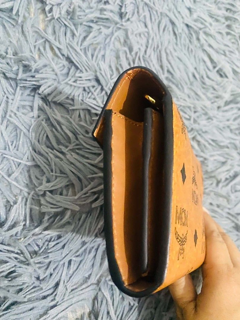 MCM Wallet on chain (Category: Luxury Bags & Wallets) located in Manila. Submitted by keendog_d33509 (Listing ID 1454681745, Image 3). Description: - Classic MCM wallet on chain - Signature Visetos print in warm cognac color - Multiple card slots for organization - Zippered coin pocket - Secure gold hardware closure on the front - Shows some signs of wear. *You can check all details before you confirm. *NO RETURN, NO REFUND ONCE TRANSACTION IS CO