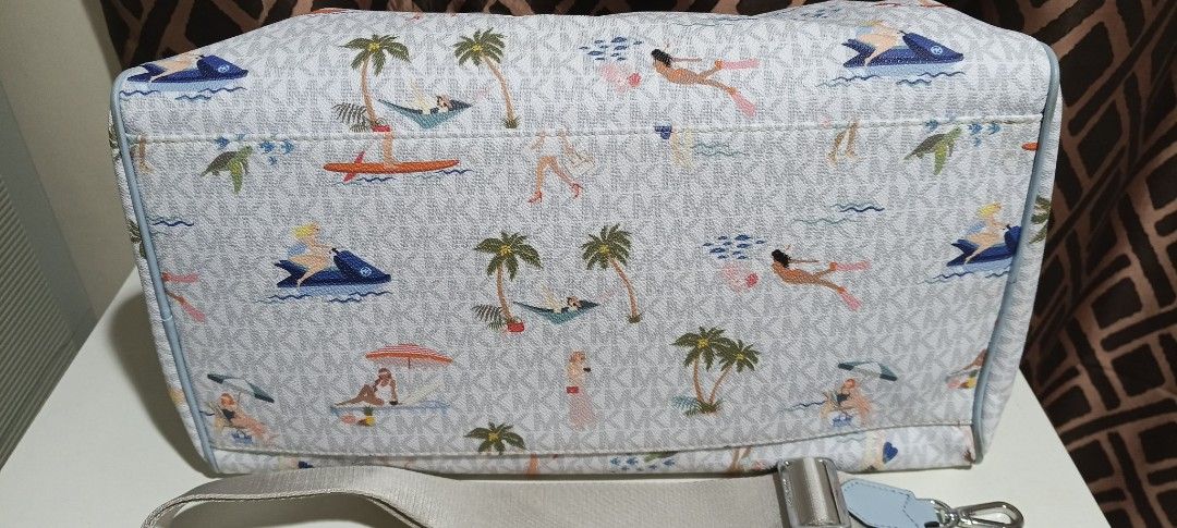 Michael Kors Monogram Beach Print Satchel Bag (Category: Luxury Bags & Wallets) located in Pavia. Submitted by taurusgirl74 (Listing ID 1454680781, Image 3). Description: - Fun beach print Michael Kors satchel bag - All-over MK monogram pattern - Light blue leather trim and handles - Includes a detachable shoulder strap - Multiple interior pockets for organization - Ideal for travel or everyday adventures.