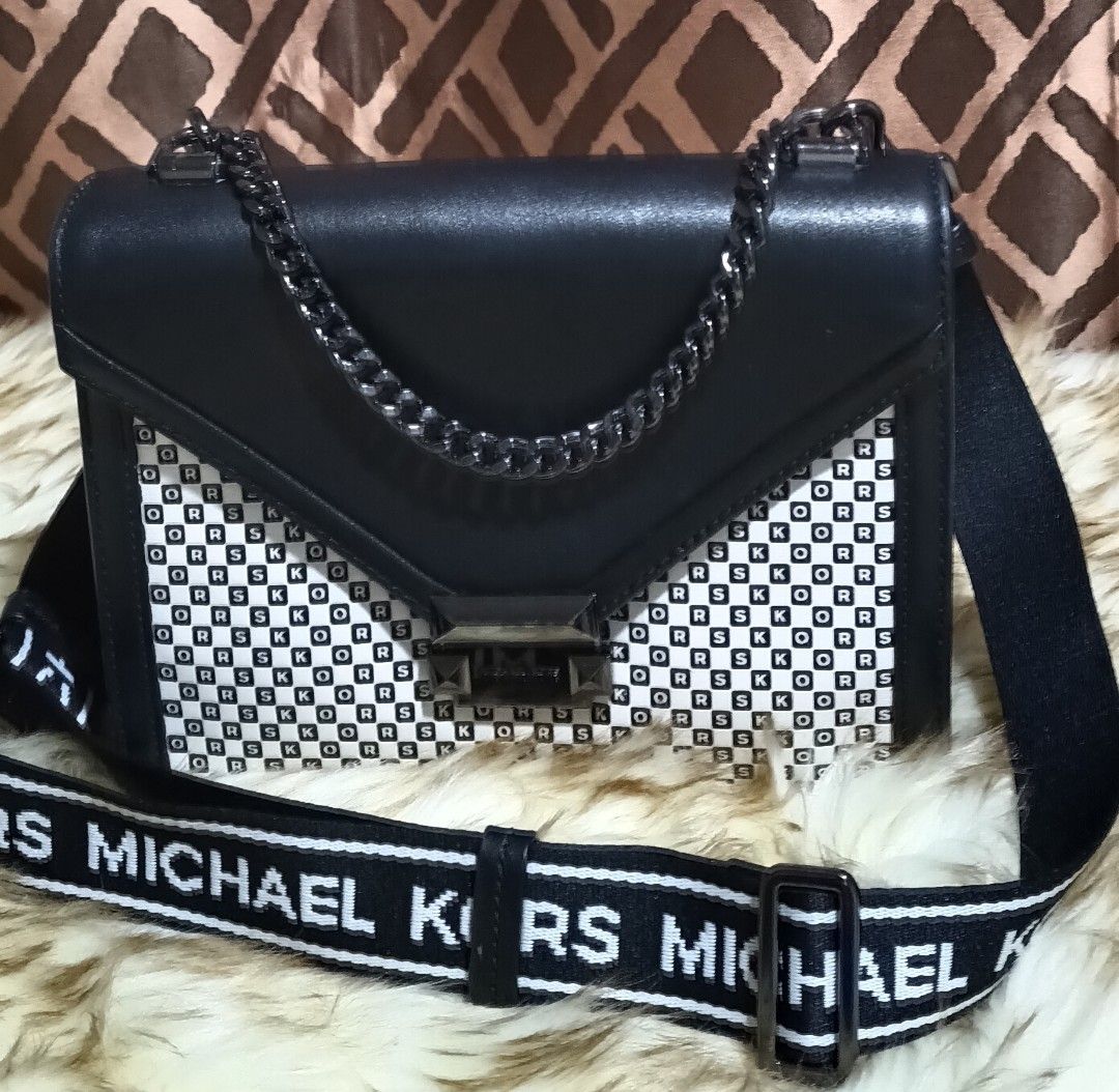 Michael Kors Whitney Leather Shoulder Bag (Category: Luxury Bags & Wallets) located in Pavia. Submitted by taurusgirl74 (Listing ID 1454681303, Image 1). Description: - Authentic Michael Kors Whitney Bag - Color: Black and White - Material: Genuine Leather - Design: Features iconic MK logo pattern on the front panel - Straps: Comes with both a chic chain strap and a longer logo strap for versatile wear - Condition: Brand new with original tag sti