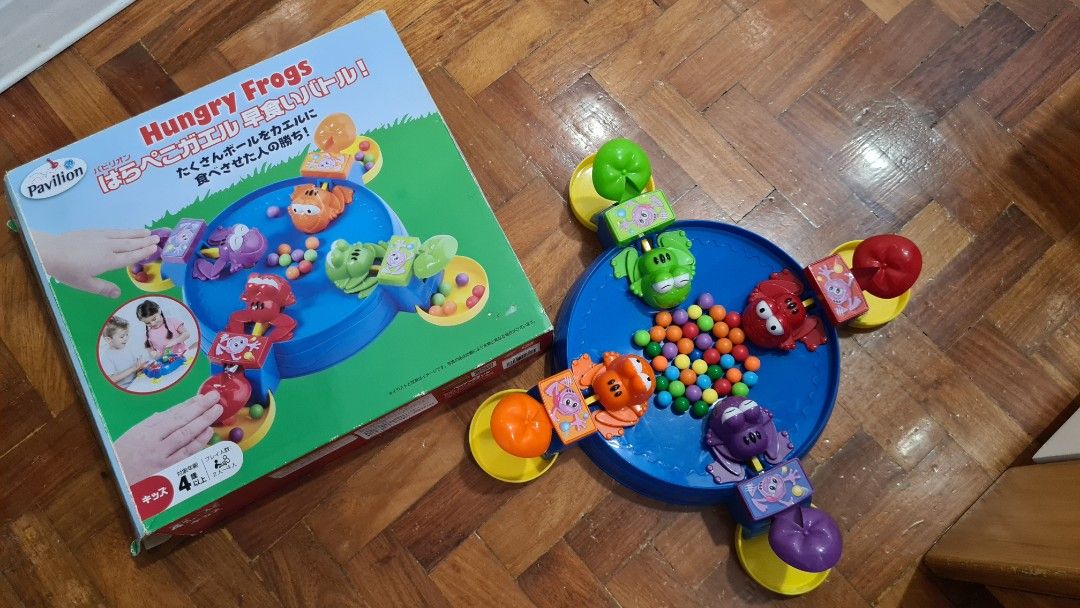 Pavilion Hungry Frogs Board Game (Category: Board Games & Puzzles) located in Manila. Submitted by lc_declut (Listing ID 1454665877, Image 1). Description: - Classic Hungry Frogs game by Pavilion - Players race to gobble up marbles with their frog - Fun for kids and families - All frogs and marbles included - Blue game board with colorful frogs - Comes with original box.