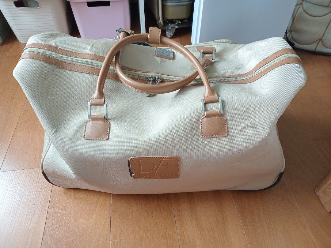 Pre-loved DVF Carry-On Weekender Bag (Category: Luxury Bags & Wallets) located in Manila. Submitted by wildocean.cad79b (Listing ID 1454605953, Image 3). Description: - Beige duffel bag with tan leather accents - Built-in wheels and retractable handle for effortless travel - Ample interior space for all your essentials - Convenient front zip pocket for quick access - Brand new with original tags still attached - Ideal for weekend getaways or as a