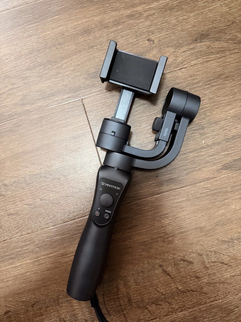 Prestigio Gimbal Stabilizer for Smartphones (Category: Gimbals & Stabilizers ) located in Pasig City. Submitted by janegar (Listing ID 1454607321, Image 2). Description: - Prestigio gimbal stabilizer for smartphones - Achieve smooth, professional-looking video shots - Ergonomic handle grip with built-in controls - Includes a wrist strap for added security - Ideal for vlogging, travel, and capturing everyday moments - leather case is peeling .