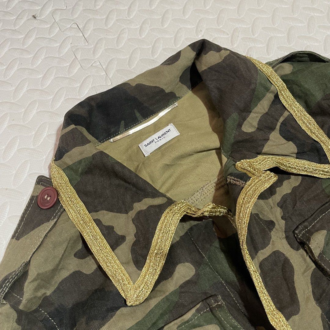 Saint Laurent Paris Camo Jacket with Gold Trim (Category: Coats, Jackets and Outerwear) located in Zamboanga. Submitted by selvege (Listing ID 1454749444, Image 2). Description: - Authentic Saint Laurent Paris jacket - Classic camouflage print - Gold trim accent on collar and placket - Button closure with branded buttons - Made in Italy - Size 42 Dimes 21.5 x 28.