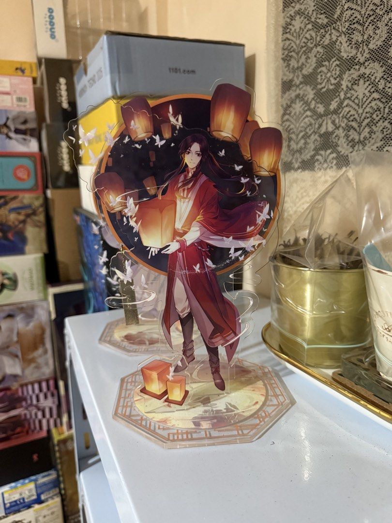 TGCF Acrylics (set only) (Category: Character Goods) located in Pasig City. Submitted by boredtakoyaki (Listing ID 1454599203, Image 2). Description: - Adorable anime acrylic standee - Features a main character with a hat and lanterns - Includes a background character - Decorated with numerous small butterflies and lanterns - Comes with a uniquely designed base - Ideal for anime enthusiasts' desks or shelves.