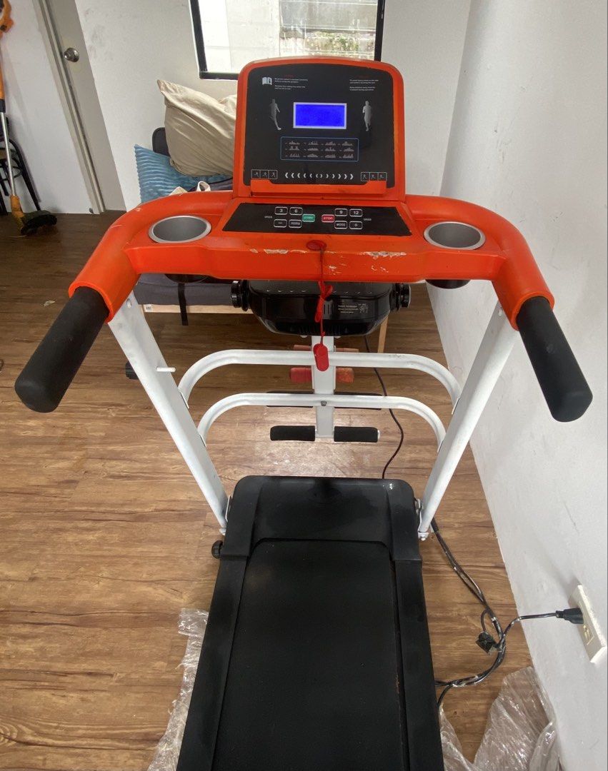 Treadmill Secondhand Good Condition (Category: Cardio & Fitness Machines) located in Manila. Submitted by relovedmnl (Listing ID 1454565208, Image 3). Description: - Features a vibrant orange and white color scheme. - Equipped with a digital display console for tracking workouts. - Includes convenient cup holders. - Suitable for home cardio workouts..