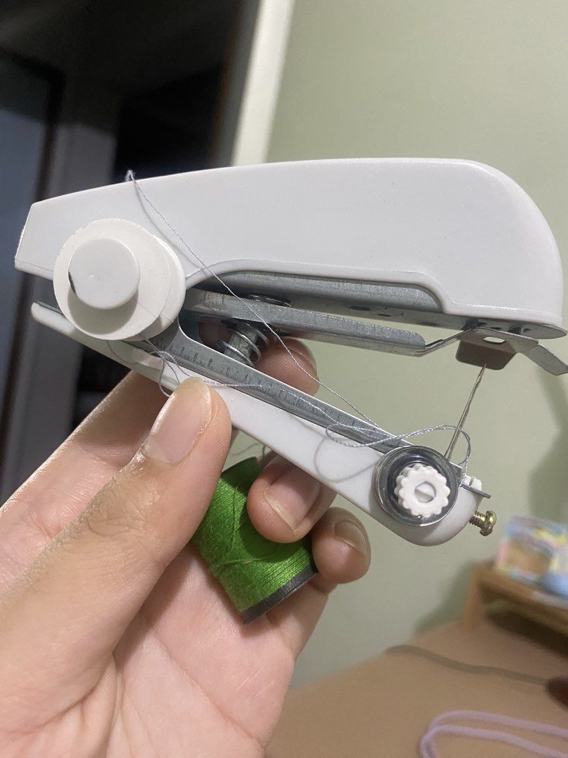 White Portable Handheld Sewing Machine with Green Thread Spool (Category: Craft Supplies & Tools) located in Manila. Submitted by nicolezald25729 (Listing ID 1454741233, Image 2). Description: - Compact handheld sewing machine - Ideal for quick repairs and small projects - Comes with a green thread spool - Easy to use for mending clothes or fabric crafts - Lightweight and portable design - Perfect for home storage or travel Rfs: My sister doesn’t