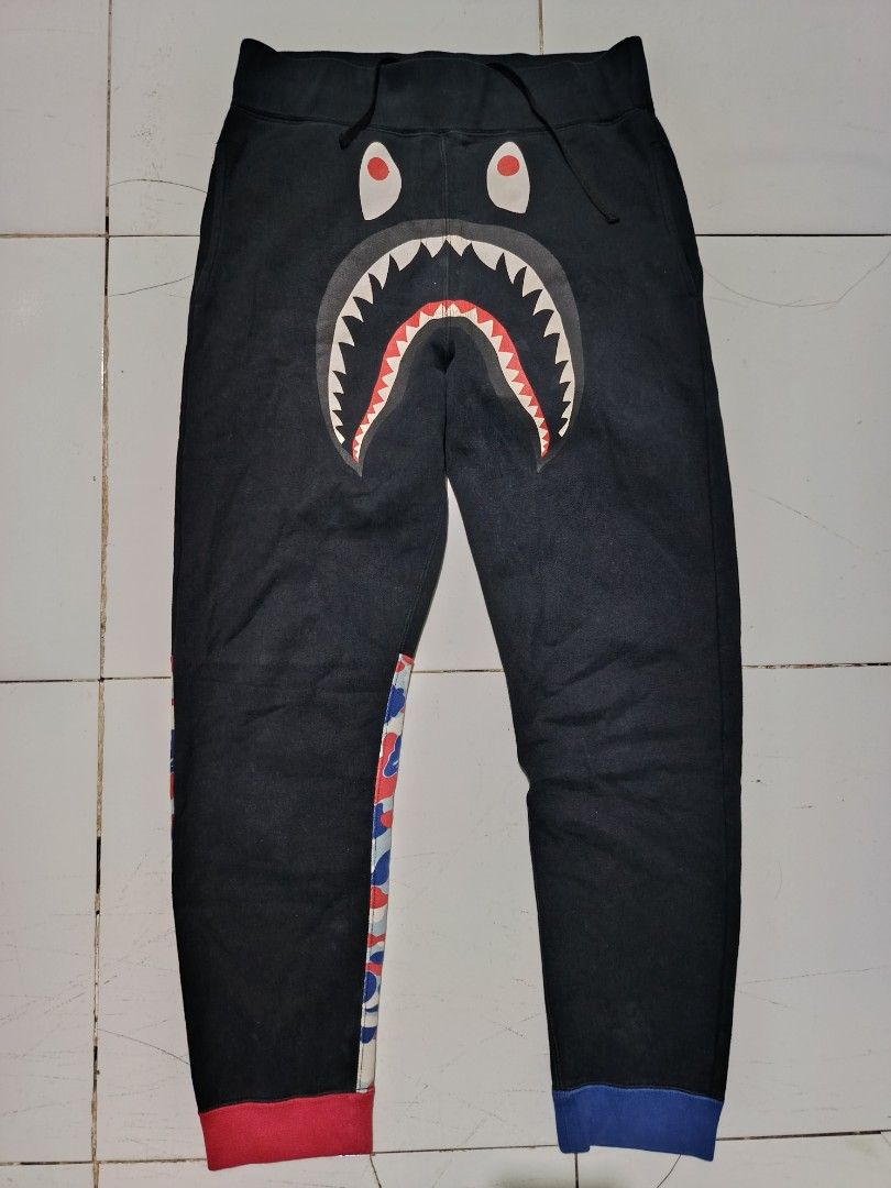 A Bathing Ape BAPE Shark Camo Sweatpants (Category: Joggers) located in Barotac Nuevo. Submitted by gray101 (Listing ID 1459022944, Image 1). Description: - Authentic BAPE Shark Sweatpants - Color: Black - Size: Medium (M) - Features iconic BAPE shark graphic on front - Tiger graphic on one leg - Camo pattern with 'BAPE' lettering on the other leg - Comfortable elastic waistband with adjustable drawstring - Ribbed cuffs for a snug fit.